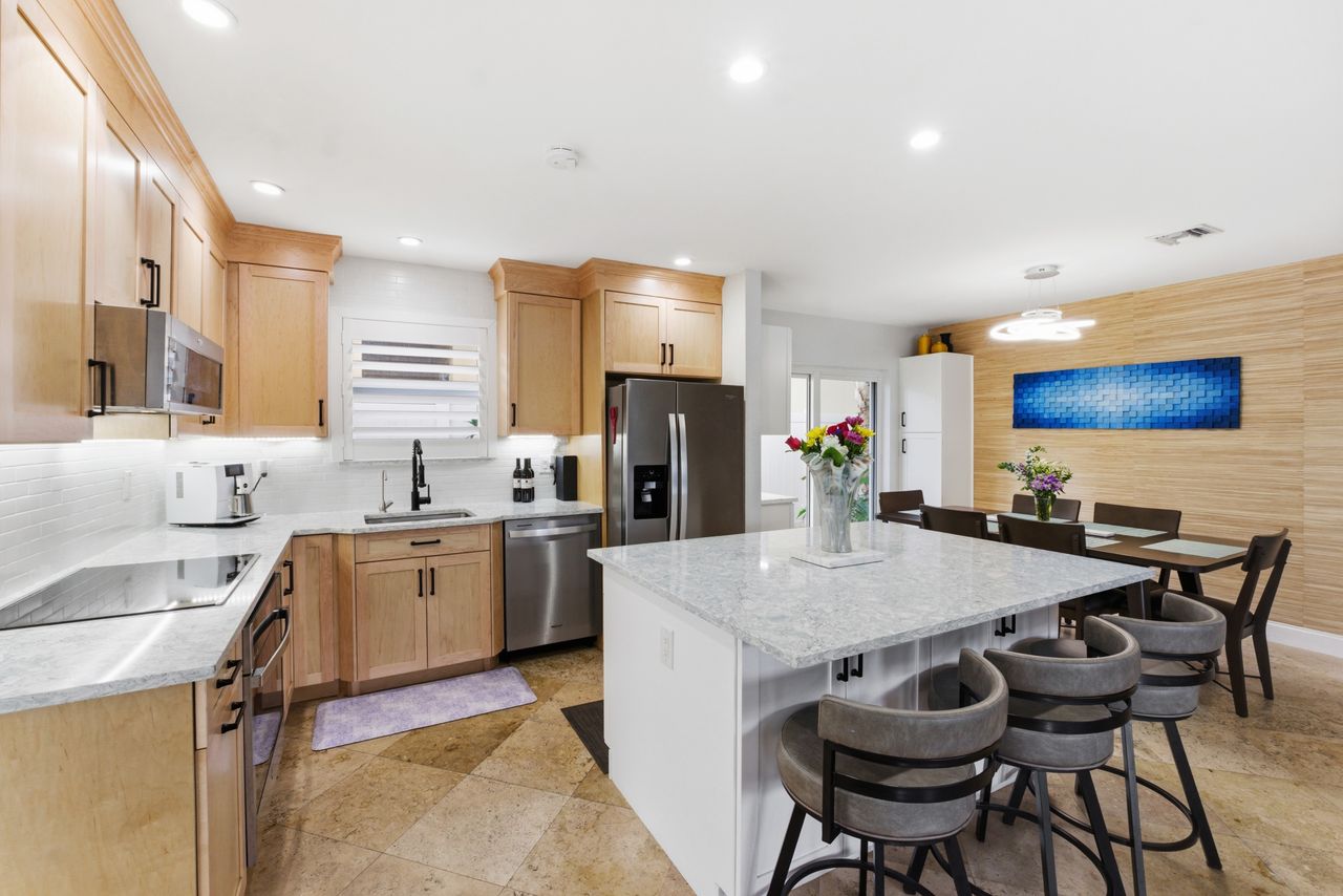Gourmet kitchen with marble island and wood cabinetry